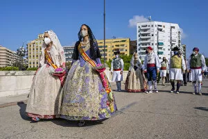 Falleras women wearing traditional dress and surgical mask in a parade during the 2021