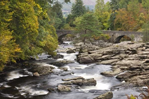 The Falls of Dochart and stone bridge surrounded by autumn foliage at Killin, Loch Lomond
