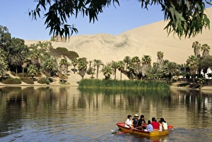 A family rows out onto the oasis lagoon of Huacachina A family rows out onto the oasis lagoon of Huacachina