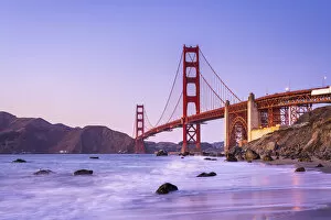 Golden Gate Bridge Collection: Famous Golden Gate Bridge over bay against blue sky during sunset, San Francisco