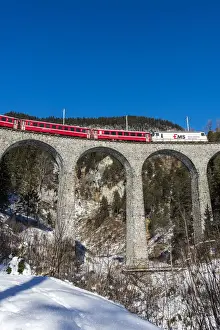 Railway Bridge Prints: The famous red train of Albula mountain railway while passing on the Landwasser viaduct