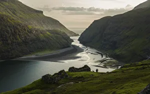 Saksun Prints: A farmer and his dog walking along the lagoon in Saksun. Streymoy, Faroe Islands