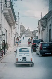 Cinquecento Prints: Fiat Cinquecento and traditional Trulli houses in Alberobello, Puglia, Italy, Europe