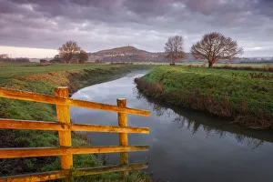 First light on Glastonbury Tor, reflected in the River Brue, Glastonbury, Somerset First light on Glastonbury Tor, reflected in the River Brue, Glastonbury, Somerset