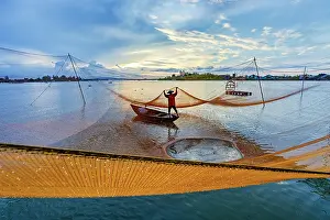 Quang Nam Province Prints: Fisherman adjusting fishing net at sunrise