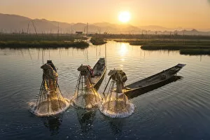Images Dated 23rd April 2020: Three fishermen catching fish from boats using traditional conical nets at sunrise