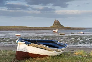 Lindisfarne Prints: Fishing boat pulled onto the shore at Holy Island, looking towards the castle, Lindisfarne