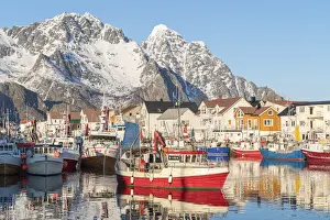 Fishing boats in the harbour, with snowcapped mountains in the background. Henningsvaer