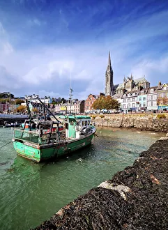 Fishing boats at the waterfront and St. Colman's Cathedral, Cobh, County Cork, Ireland
