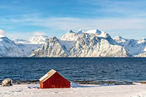 Fjord Prints: Fishing hut on a beach with Lyngen Alps on background