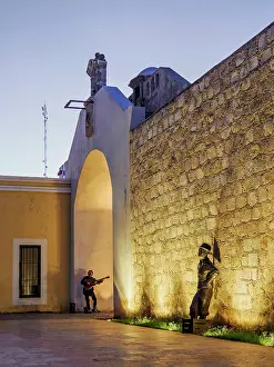 Fishmonger Prints: Fishmonger statue and the musician playing guitar at Puerta de Mar at dusk