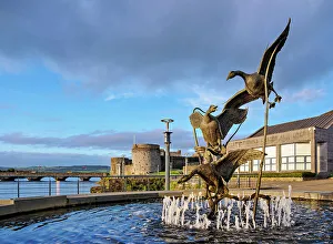 Images Dated 31st March 2023: Flight of the Wild Geese Fountain of Heritage with King John's Castle in the background at sunset