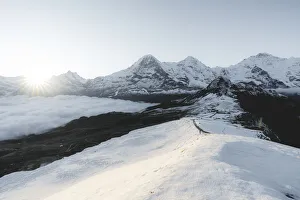 Foggy sky at dawn on the snowcapped Eiger, Monch and Jungfrau peaks, Mannlichen, Jungfrau Region, Berner Oberland Foggy sky at dawn on the snowcapped Eiger, Monch and Jungfrau peaks, Mannlichen, Jungfrau Region, Berner Oberland
