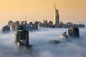 Top View Collection: Foggy sunrise with Dubai Marinas skyscrapers towering over the low clouds