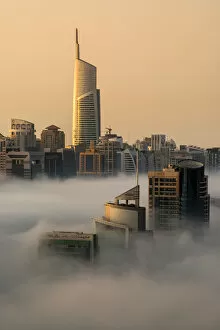 Top View Collection: Foggy sunrise with Dubai Marins skyscrapers towering over the low clouds, Dubai