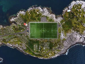 Close Up Gallery: The football field of Henningsvaer framed by the rocks of the coast. Lofoten Islands, Norway