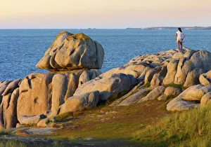France, Brittany, Finistere, Cleder, woman standing on granite rocks (MR)