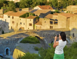 Images Dated 30th September 2013: France, Languedoc, Lagrasse, woman photographing bridge (MR)