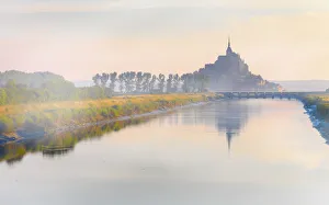 France, Normandy, Le Mont Saint Michel, shrouded in fog at dawn, reflected in river