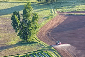 Images Dated 5th June 2023: France, Nouvelle-Aquitaine, Dordogne, Perigord, Domme, a tractor sprays a field near Domme