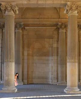 France, Paris, The Louvre, girl aged 8 hiding behind pillar (MR)