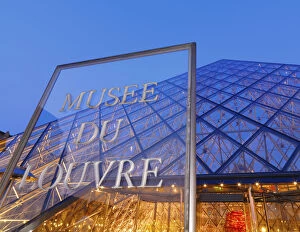 France, Paris, The Louvre, sign and pyramid illuminated at night