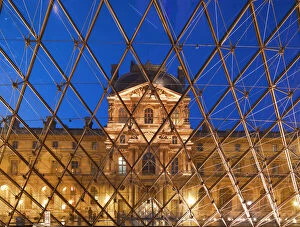 France, Paris, The Louvre, view through pyramid illuminated at night