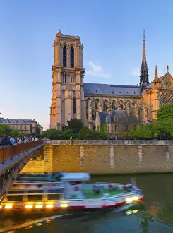 Ile De France Prints: France, Paris, Notre Dame Cathedral and tour boat on River Seine at dusk
