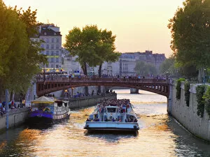 France, Paris, Tourboat on River Seine at sunset