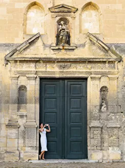 France, Provence, Arles, Notra Dame de la Major, Woman taking photograph in church