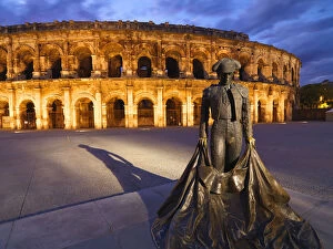 France, Provence, Nimes, Roman ampitheatre, Toreador statue at dusk