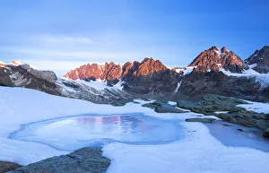Dawns Prints: Frozen lake during sunrise on the Bernina mountain range. Bocchetta delle Forbici