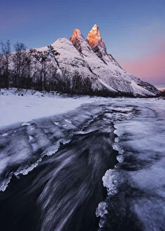 Stream Gallery: Frozen river and Mt. Otertinden taking the first lights of the day, Tromso region, Norway