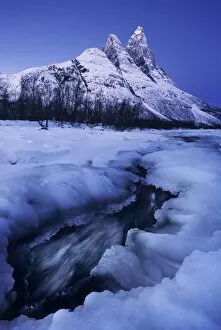 Images Dated 13th July 2020: Frozen river and Mt. Otertinden taking the first lights of the day, Tromso region, Norway
