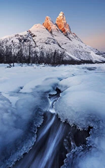Peaks Gallery: Frozen river and Mt. Otertinden taking the first lights of the day, Tromso region, Norway