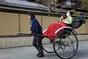 Images Dated 9th November 2011: Geishas travelling in a rickshaw, Kyoto, Japan