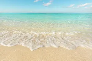 Sandy Prints: Gentle waves rolling in at Seven Mile Beach on the Caribbean Sea