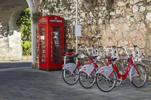 Icon Prints: Gibraltar, Gibraltar, British red telephone box and hire bikes by Southport Gates