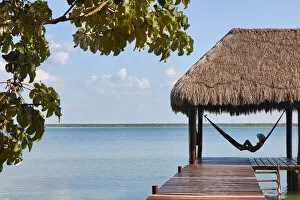 Images Dated 7th June 2022: Girl with hat in a hammock looking at Bacalar lagoon from a pier, Quintana Roo, Yucatan, Mexico