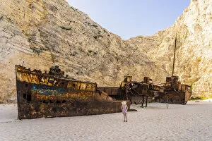 Images Dated 15th June 2022: A girl in a hat looking at the shipwreck on Navagio Beach or Shipwreck Beach, Zakynthos, Zante