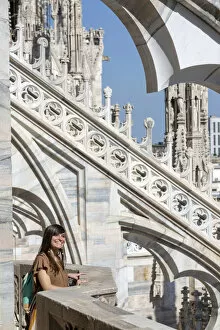 Girl smiling near spires of Milan Cathedral, Lombardy, Italy