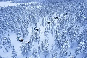 Design Prints: Glass cabins set on the middle of the frozen forest covered with snow at dusk