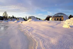 Blizzard Prints: Glass igloo of a luxury tourist resort covered with snow on the banks of a frozen river