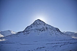 Images Dated 10th June 2011: Glen Coe, Scotland. The sun hides behind Meall Mor in snow covered Glen Coe