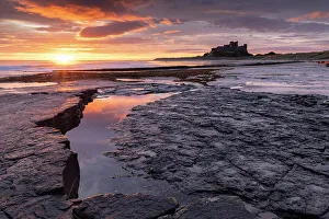 Q2 2023 Collection: Glorious sunrise above Bamburgh Castle on the Northumberland coast, England. Autumn (October) 2021