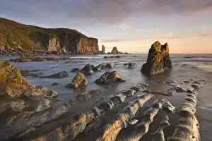 South Hams Prints: Golden evening sunlight bathes the rocks and ledges at Bantham in the South Hams
