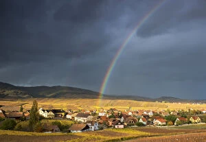 Golden light and rainbow over Hunawihr surrounded by the vineyards of Grand Cru in Alsace
