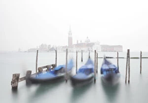 Gondolas moored at the Bacino di San Marco with a slightly visible Church of San Giorgio Maggiore