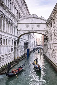 Gondoliers on a canal at Bridge of Sights, as seen from Ponte della Paglia. Venice
