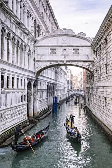 Marble Gallery: Gondoliers on a canal at Bridge of Sights, as seen from Ponte della Paglia. Venice